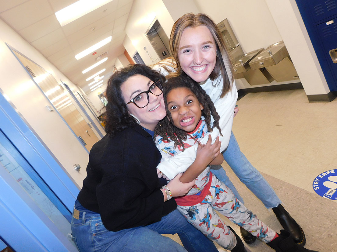 teachers hugging a student making a silly face